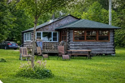 a log cabin with a table and chairs in the yard at Balsam Lake - 2-Bedroom Cottage #6 in Kawartha Lakes