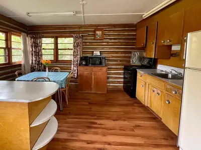a kitchen with wooden cabinets and a table with a tableablish at Balsam Lake - 2-Bedroom House in Kawartha #15 in Kawartha Lakes