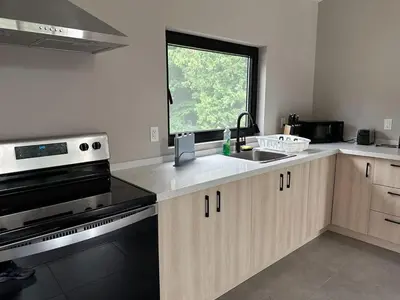 a kitchen with a stove and a sink and a window at 3-bedroom Lakefront Villa #7 in Lakefield