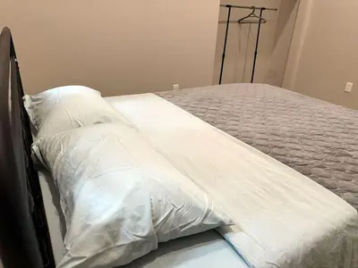 a bed with white sheets and pillows on it at 3-bedroom Lakefront Villa #7 in Lakefield