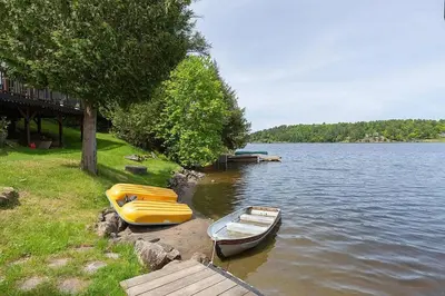 two boats sitting on the shore of a lake at Muskoka Cabana - Sandy beach cottage in Muskoka in Utterson