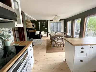 a kitchen with a table and a dining room at Muskoka Cabana - Sandy beach cottage in Muskoka in Utterson