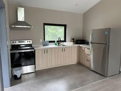 a kitchen with a stainless steel refrigerator and a window at 3-bedroom Villa in Lakefield #17 in Lakefield