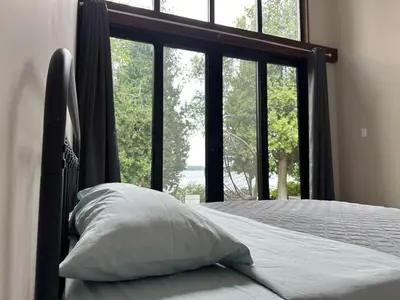 a bed with a pillow in front of a window at 3-bedroom Lakefront Villa #10 in Lakefield