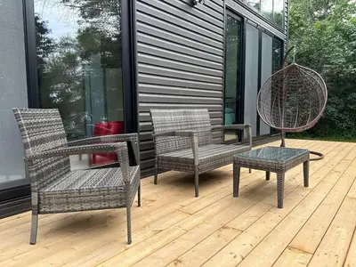 three wicker chairs and a table on a deck at 3-bedroom Lakefront Villa #10 in Lakefield