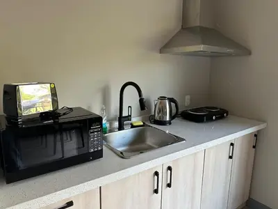 a kitchen counter with a sink and a microwave at 3-bedroom Villa in Lakefield #15 in Lakefield