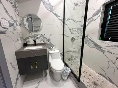 a bathroom with a toilet and a sink and a mirror at 3-bedroom Lakefront Villa #2 in Lakefield