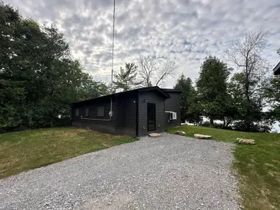 a small black building on a gravel driveway at 3-bedroom Lakefront Villa #2 in Lakefield