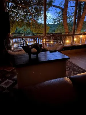 a living room with a table and a large window at The Muskoka Nest in Utterson