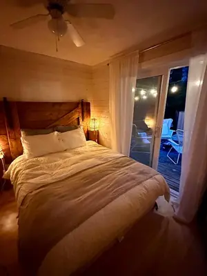 a bedroom with a large bed and a balcony at The Muskoka Nest in Utterson