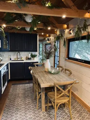 a kitchen with a wooden table and chairs at The Water’s Edge * * Unique Muskoka Treehouse * * in Utterson