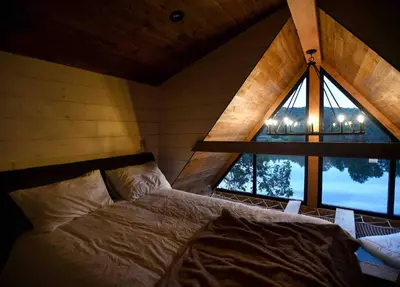 a bedroom with a bed and a large window at The Water’s Edge * * Unique Muskoka Treehouse * * in Utterson