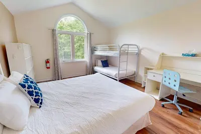 a bedroom with a bed and a desk and a bunk bed at Monterra in Collingwood