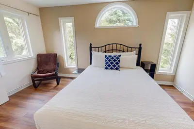 a bedroom with a large bed with two windows at Monterra in Collingwood