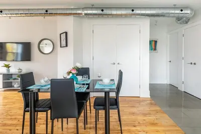 a dining room with a black table and chairs at Stylish & Pet-Friendly 2BR Suite in Trendy Leslieville with Portable AC Nearest Intersection Eastern Ave in Toronto
