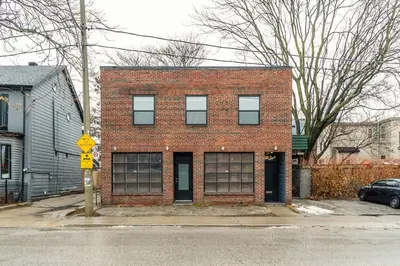 a red brick building on the corner of a street at Stylish & Pet-Friendly 2BR Suite in Trendy Leslieville with Portable AC Nearest Intersection Eastern Ave in Toronto