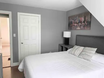 a bedroom with a white bed and a painting on the wall at Wares Muskoka Lakes Estate in Gravenhurst