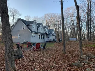 a large house with chairs in front of it at Wares Muskoka Lakes Estate in Gravenhurst