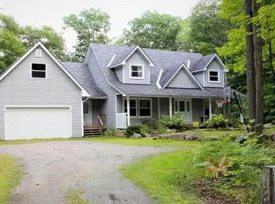 a large white house with a garage at Wares Muskoka Lakes Estate in Gravenhurst