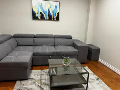 a living room with a gray couch and a glass table at Three Bedrooms House in Mississauga with free parking Conveniently located with easy access to the airport downtown Toronto major malls and highways for a seamless stay in Mississauga