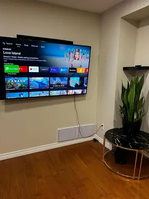 a flat screen tv hanging on a wall at Three Bedrooms House in Mississauga with free parking Conveniently located with easy access to the airport downtown Toronto major malls and highways for a seamless stay in Mississauga