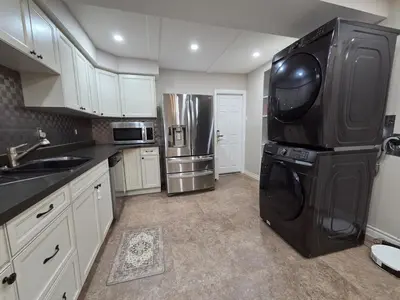 a kitchen with a black refrigerator and a microwave at Three Bedrooms House in Mississauga with free parking Conveniently located with easy access to the airport downtown Toronto major malls and highways for a seamless stay in Mississauga