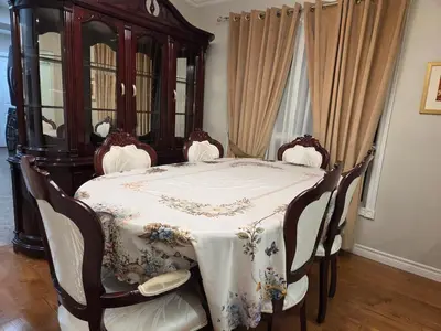 a dining room with a table with chairs and a dresser at Three Bedrooms House in Mississauga with free parking Conveniently located with easy access to the airport downtown Toronto major malls and highways for a seamless stay in Mississauga