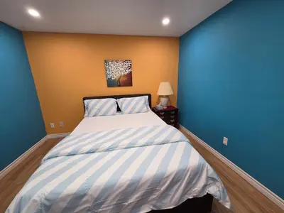 a bedroom with a bed with blue and yellow walls at Three Bedrooms House in Mississauga with free parking Conveniently located with easy access to the airport downtown Toronto major malls and highways for a seamless stay in Mississauga