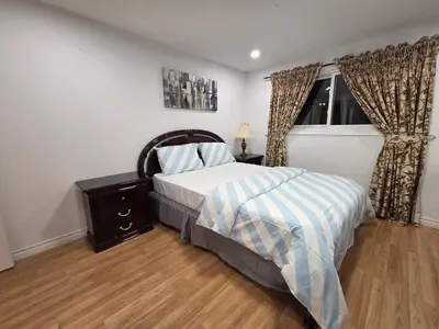 a bedroom with a bed and a window at Three Bedrooms House in Mississauga with free parking Conveniently located with easy access to the airport downtown Toronto major malls and highways for a seamless stay in Mississauga