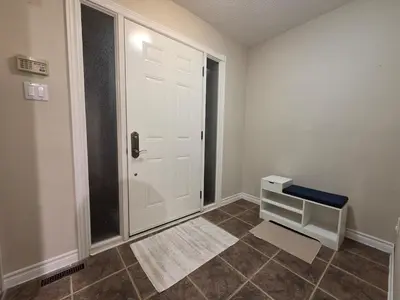 a room with a white door and a tile floor at Three Bedrooms House in Mississauga with free parking Conveniently located with easy access to the airport downtown Toronto major malls and highways for a seamless stay in Mississauga
