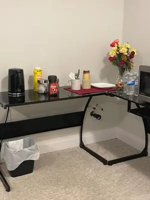 a black desk with a vase of flowers on it at Spacious Luxury walk out Basement in Kitchener