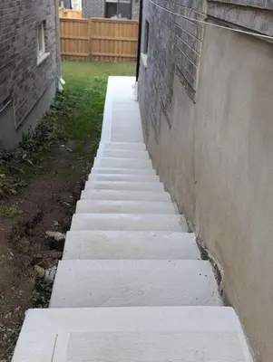 a concrete sidewalk next to a wall next to a building at Spacious Luxury walk out Basement in Kitchener