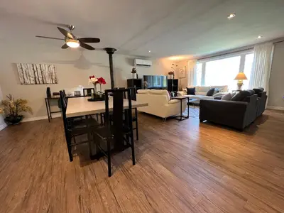 a living room with a ceiling fan and a table at The Beach House - Steps to Beach Area 3 4BR in Wasaga Beach