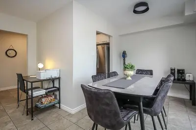 a dining room with a table and chairs at Spacious Second Floor Garden View Apartment in Wasaga Beach
