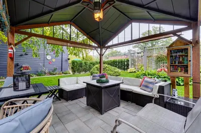 a pavilion with a couch and chairs on a patio at Spacious Second Floor Garden View Apartment in Wasaga Beach