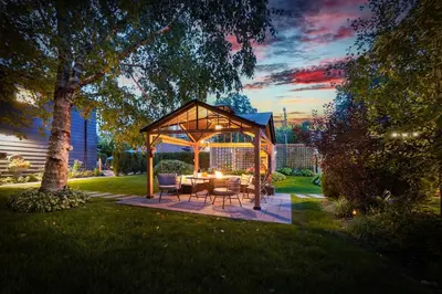 a gazebo with a table and chairs in a yard at Spacious Second Floor Garden View Apartment in Wasaga Beach
