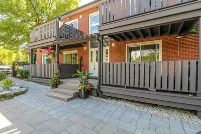 a brick house with a fence and a patio at Spacious Second Floor Garden View Apartment in Wasaga Beach