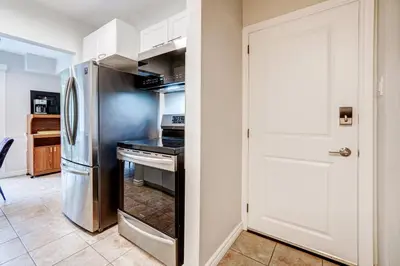 a kitchen with a refrigerator and a stove at Spacious Second Floor Garden View Apartment in Wasaga Beach