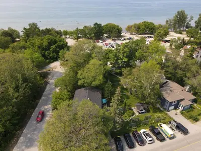 an aerial view of a house with cars parked in a parking lot at The Cozy Shore Cottage - Large in Wasaga Beach