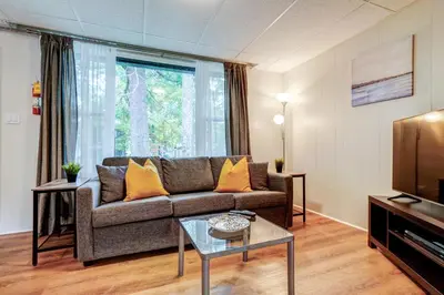 a living room with a couch and a tv at The Cozy Shore Cottage - Large in Wasaga Beach