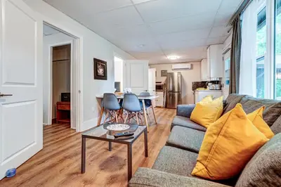 a living room with a couch and a table at The Cozy Shore Cottage - Large in Wasaga Beach