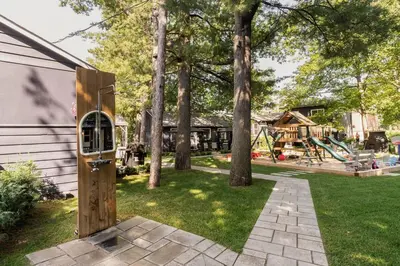 a backyard with a play yard with a playground at The Cozy Shore Cottage - Standard Single in Wasaga Beach