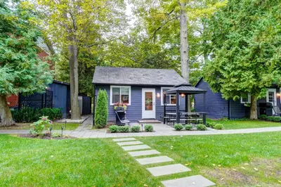 a blue tiny house in a yard at The Cozy Shore Cottage - Standard Single in Wasaga Beach