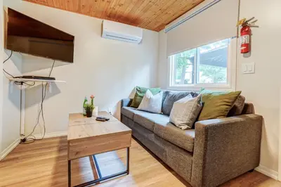 a living room with a couch and a table at The Cozy Shore Cottage - Standard Single in Wasaga Beach