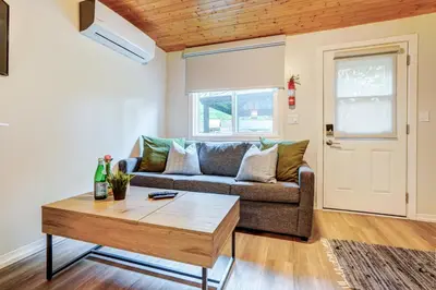 a living room with a couch and a coffee table at The Cozy Shore Cottage - Standard Single in Wasaga Beach