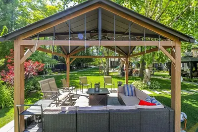 a gazebo with a couch and chairs in a yard at The Cozy Shore Cottage - Standard Single in Wasaga Beach