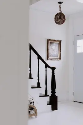 a black staircase in a white room with a picture at The Wild Rose - Cozy PEC Rental in Picton in Picton