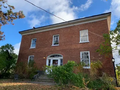 an old red brick building with white windows at The House of Elsie Bed and Breakfast in Niagara on the Lake