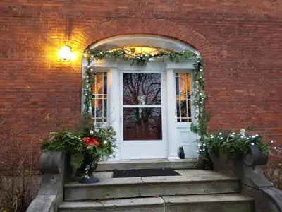 a front door of a brick house with flowers on the stairs at The House of Elsie Bed and Breakfast in Niagara on the Lake