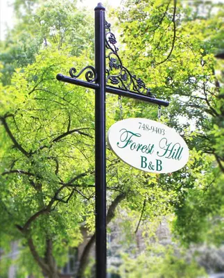 a sign on a black pole with trees in the background at Forest Hill Bed and Breakfast in Kitchener